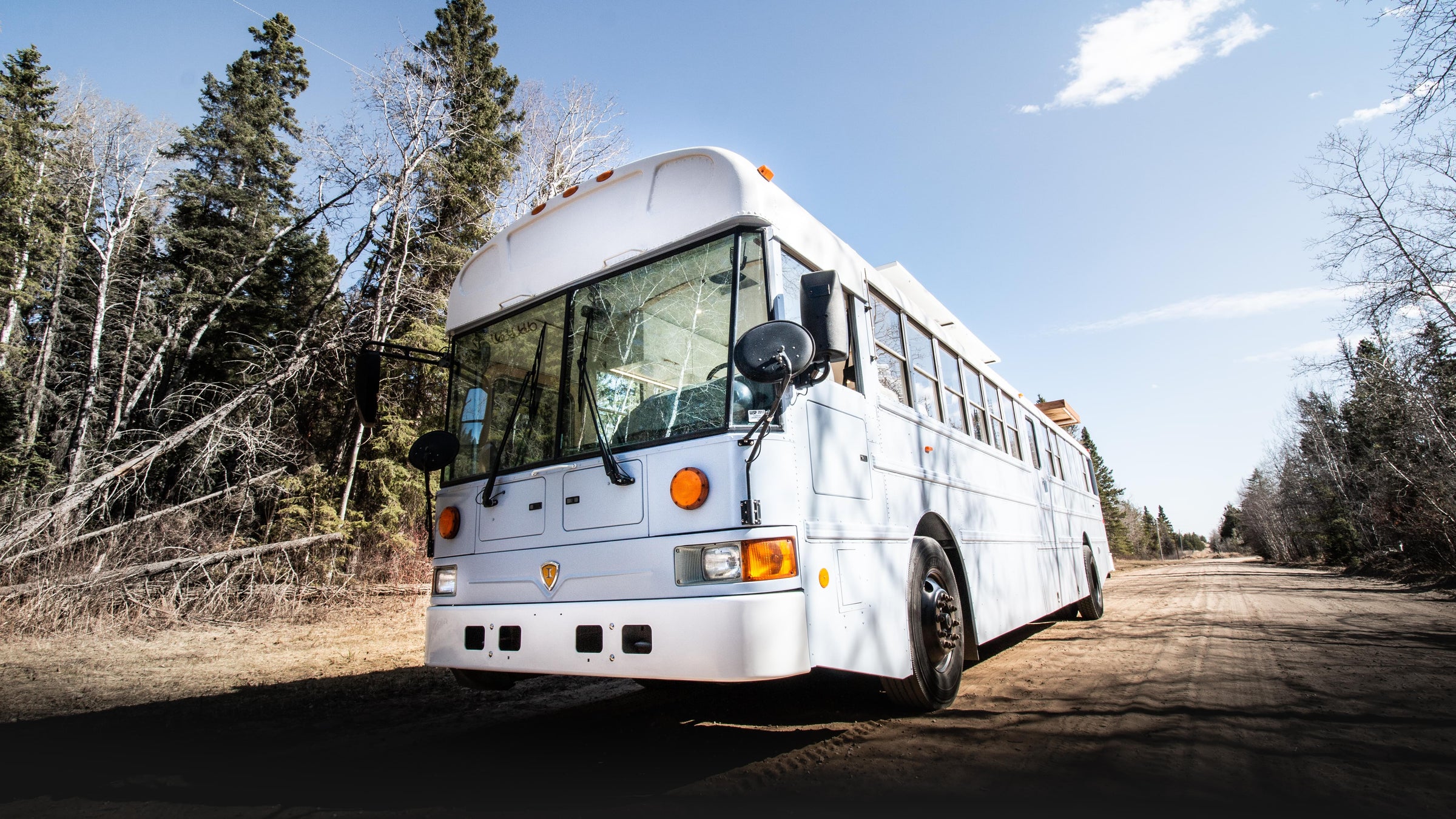 baby blue school bus conversion with a white roof